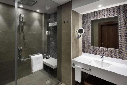 麦加Park Inn by Radisson Makkah Aziziyah的浴室配有盥洗盆和带镜子的淋浴