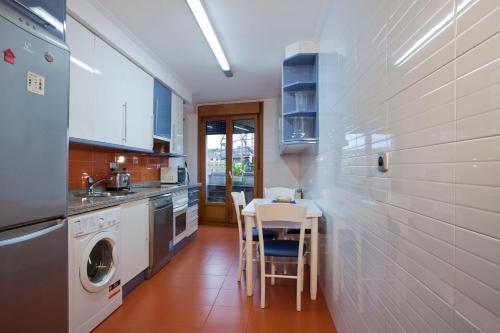 奥维多Apartamento de La Casona de Riomera的厨房配有桌子、水槽和洗碗机。
