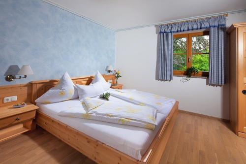 马克特谢伦贝格Ferienwohnungen Zweckl的一间卧室配有一张带白色床单的床和一扇窗户。