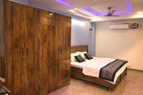 新德里CASA CENTRAL的一间卧室配有一张床和一个大型木制橱柜