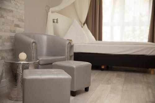 柏林柏林基兹潘森酒店的一间卧室配有床、椅子和凳子