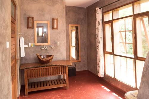 Murchison Falls National ParkTwiga Safari Lodge的一间带木制水槽和镜子的浴室