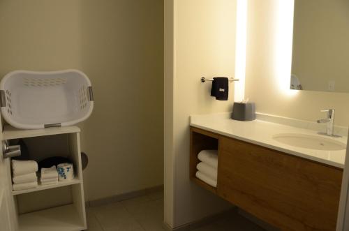 默夫里斯伯勒Staybridge Suites Nashville SE - Murfreesboro, an IHG Hotel的浴室配有盥洗盆、镜子和毛巾