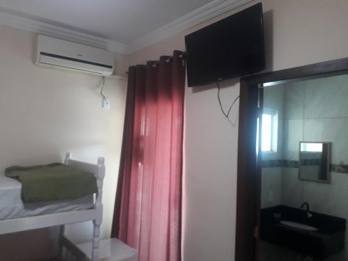 佩尼亚Pousada Ilha do Itacolomi的一间卧室配有一张双层床和一台墙上的电视。