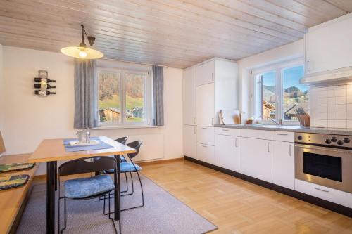 比曹Wohnung Kanisfluhblick的厨房配有白色橱柜和桌椅