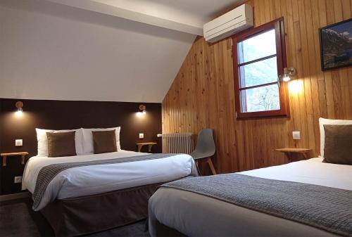 皮埃尔菲特－内斯塔拉德拉盖尔酒店的酒店客房设有两张床和窗户。