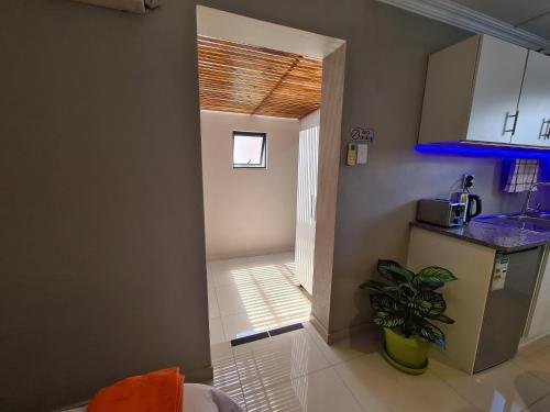德班ARCHITECTS VIEW - VIP FAMILY SUITE的一个带水槽的厨房和一个通往走廊的门