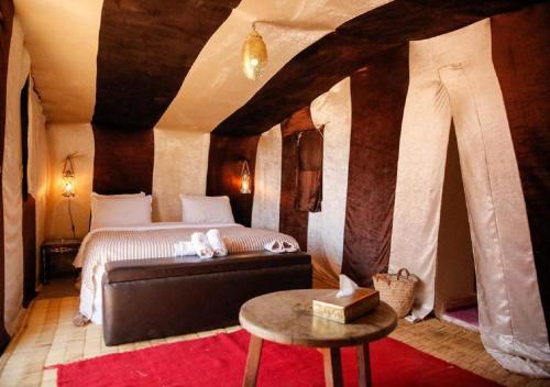 姆哈米德Mhamid Luxury Camp Experience的卧室配有一张床和一张桌子