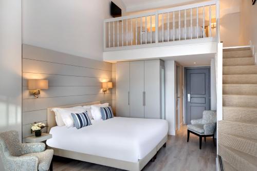 比奥La Bastide de Biot的卧室配有白色的床和楼梯。