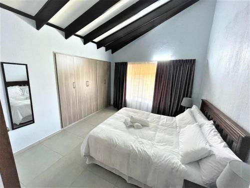 谢丽海滩63 Cest Si Bon - Shelly Beach的卧室配有白色大床和白色枕头
