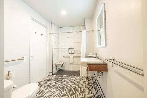 魁北克市Hôtel Manoir Vieux-Québec的白色的浴室设有水槽和卫生间。