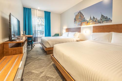 魁北克市Hôtel Manoir Vieux-Québec的酒店客房设有两张床和一台平面电视。