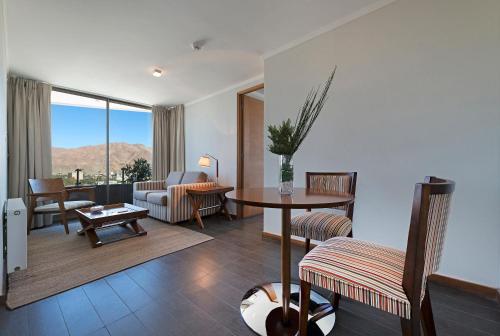 科皮亚波阿塔卡马套房酒店的客厅配有桌椅和沙发