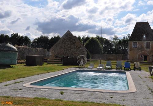 MargonManoir du Bois Joly - Roulotte Gitane的一个带椅子的庭院和房子的游泳池