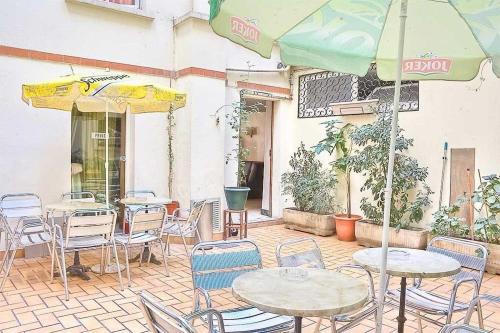 巴黎布鲁塞尔酒店的一个带桌椅和遮阳伞的庭院
