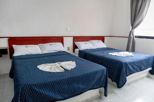 比亚埃尔莫萨Hotel Madero的配有两张蓝色和白色床单的床铺