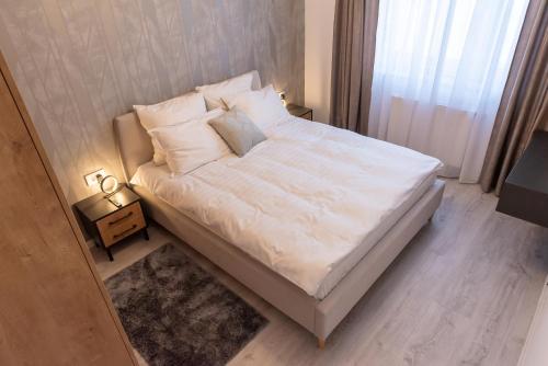 布拉索夫Apart B&V的卧室内的一张带白色床单和枕头的床