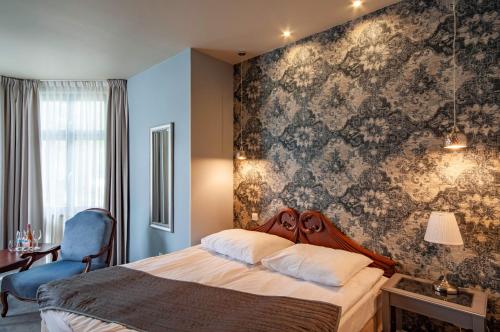 米兹多洛杰Monaco Ville的一间卧室配有一张带花卉壁纸的床