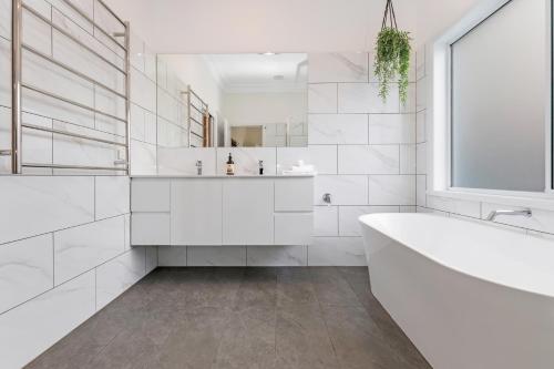 莫阿马5 Simms - Echuca Holiday Homes的白色的浴室设有浴缸和窗户。