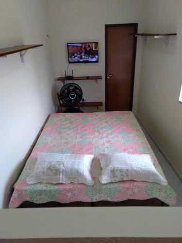 卡博迪圣阿戈斯蒂尼奥Kitnet 2,vista fantastica的一间卧室配有一张带粉色毯子的床