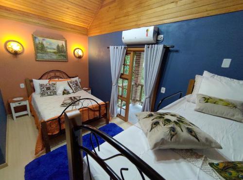 格拉玛多Cabana Drechsler Gramado的一间卧室设有两张单人床和一个窗户。