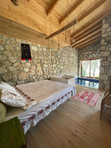 帕塔拉Shavilla Kalkan - Yalı ' da Korunaklı 1+1 Villa的卧室配有一张石墙床