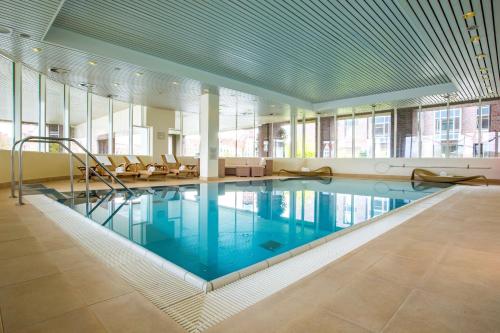 吕贝克鲁贝克参议员丽笙酒店的大型客房带窗户,设有大型游泳池