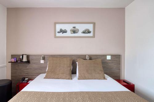 圣埃尔布兰Sure Hotel by Best Western Nantes Saint-Herblain的卧室配有白色的床和2个枕头