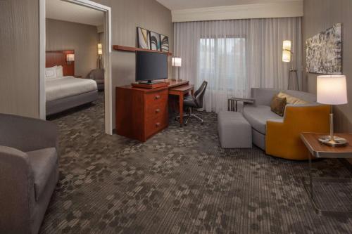 纽瓦克威尔明顿纽瓦克/克里斯蒂安娜购物中心万怡酒店的酒店客房设有一张沙发和一张带电视的书桌。