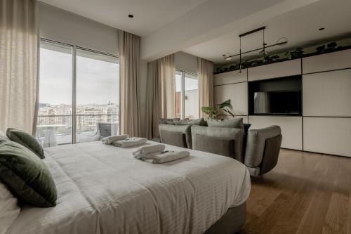 雅典Athinaion Recreation Suites的一间卧室配有一张大床、椅子和电视