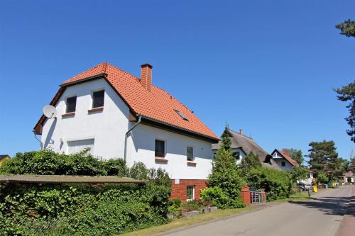 格拉尔-米里茨Ferienwohnung Graal Mueritz MOST 2301的街上有红色屋顶的白色房子