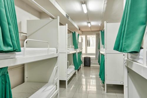 巴塞罗那侯拉典范旅馆的一间设有白色双层床和绿色窗帘的房间