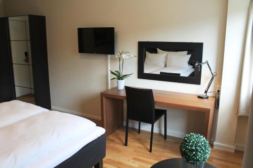 StørenStøren Hotel的一间卧室配有一张桌子、一张床和一面镜子