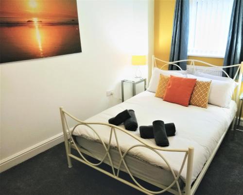 圣海伦斯Modern comfy 2-Bedroom flat in St Helens的卧室配有白色的床和色彩缤纷的枕头