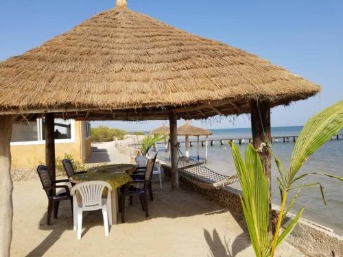 Mar LodjCap Marniane的海滩上的餐厅,带草伞