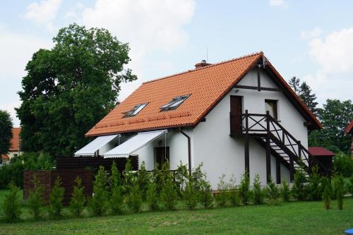 雷泽沃Mazurska Apartamenty的白色房子,有橙色屋顶