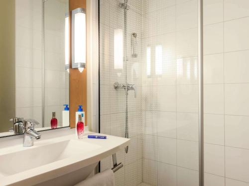 贡比涅贡比涅宜必思酒店的带淋浴和盥洗盆的白色浴室
