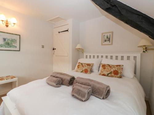 谢伯恩Snowdrop Cottage的卧室配有白色的床和两个枕头
