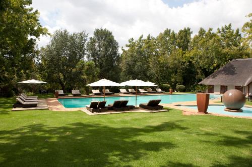 马加利斯堡Valley Lodge & Spa的庭院内带椅子和遮阳伞的游泳池
