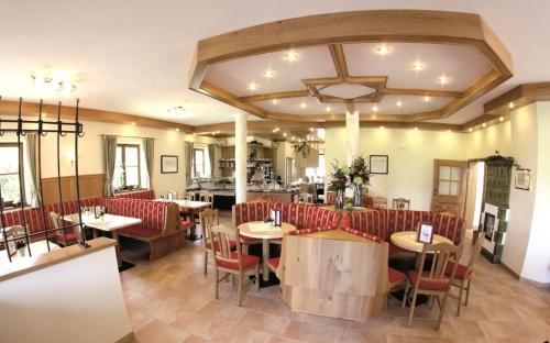 基姆湖畔贝尔瑙Cafe Wastelbauerhof - Urlaub auf dem Bauernhof的一间餐厅,房间内设有红色的椅子和桌子