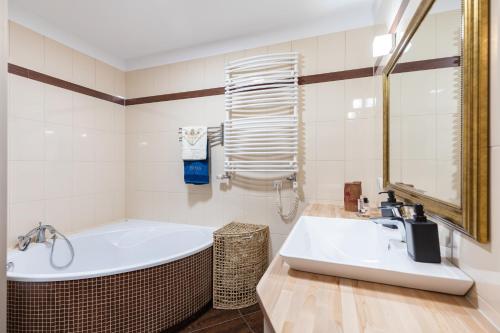 华沙SuperApart Wilanowska 7的白色的浴室设有浴缸和水槽。