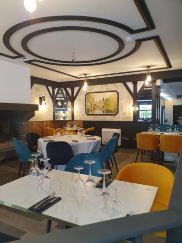 欧里亚克文艺复兴酒店的餐厅设有桌椅和酒杯