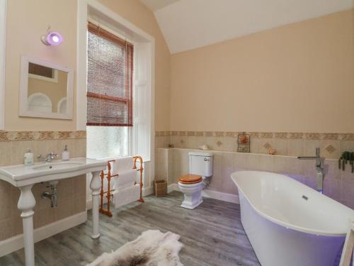 阿布罗斯Woodside House的带浴缸、盥洗盆和卫生间的浴室