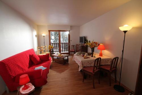 勒奥瓦尔德阿德莱德公寓的客厅配有红色的沙发和桌子