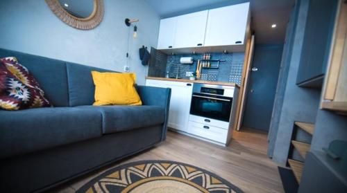 蒂涅Cosy - Appartement 2 personnes - Tignes le Lac - 415 - Le Palafour的一间带蓝色沙发的客厅和一间厨房