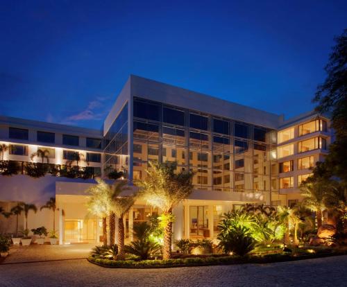 海得拉巴海德拉巴班加拉山丽笙世嘉酒店的一座棕榈树环绕的大建筑