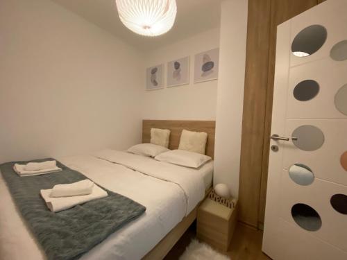 帕莱Alexandrea Apartments的一间卧室配有一张床,上面有两条毛巾