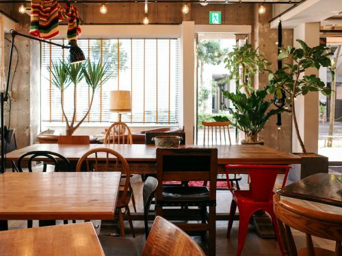 东京汤姆之家酒店 的餐厅设有木桌、椅子和窗户。