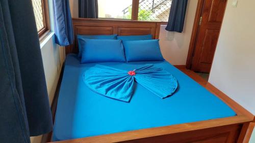 韦利格默El-Nivasa Villa in Weligama的一张蓝色的床,上面有花