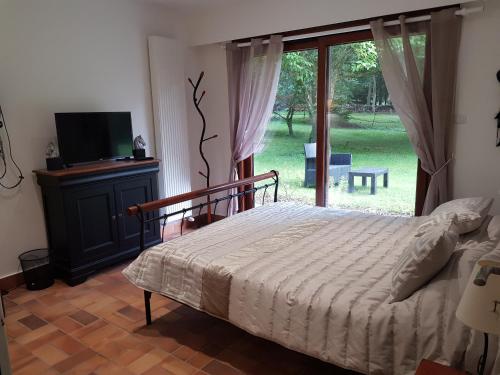 埃尔芒翁维尔Les Sabots du Parc的一间卧室设有一张床、一台电视和一个窗口。